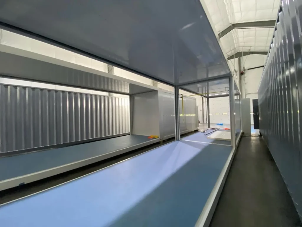 Interior view of modular container with partially assembled blue flooring.