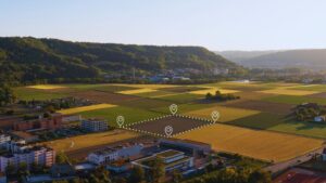 Aerial view of agricultural land and town with location markers illustrating modular home land suitability guide, showing various parcels for evaluating zoning and building requirements